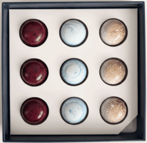 Box of assorted round chocolates in three flavors arranged in a grid.