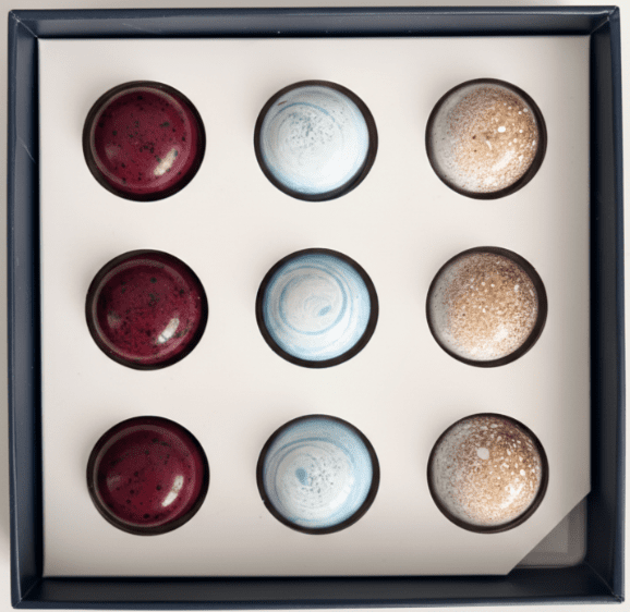 Box of assorted round chocolates in three flavors arranged in a grid.